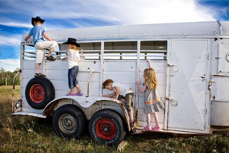 (Left to right) Tyler (age 6),  Frankie (age 5),  Jimmy (age 4) and Brilee (age 4) play on an old horse trailer
East Glacier, Montana