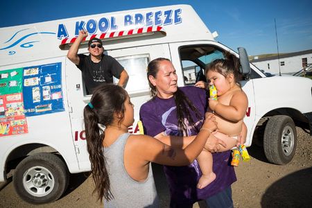 A mother purchases ice cream for daughters on the outskirts of the reservation, in a neighborhood known as FEMA-ville.  
