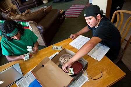 (Left to right) At the end of the workday, Robert Hall and Ian Webber calculate the days gross sales.  The Webber house is home base for the Kool Breeze business- and Ians mother,  Susan Webber does the accounting and bookkeeping for Kool Breeze
