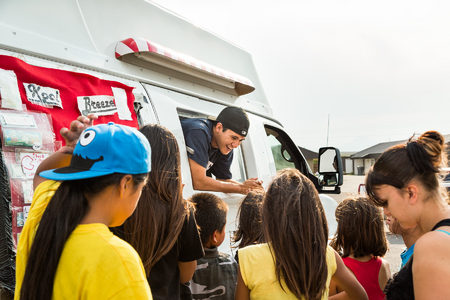 Isaiah Webber works the window as customers line up outside of the Last Star Homes housing development on the Blackfeet Reservation.