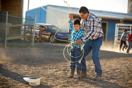 Ethan David helps his son, Josh prepare for the dummy roping competition.
