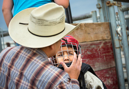Ethan David readies his terrified son, Josh for the bull riding competition.  David travel from the Canadian side of the reservation for the weekly Youth Rodeo.